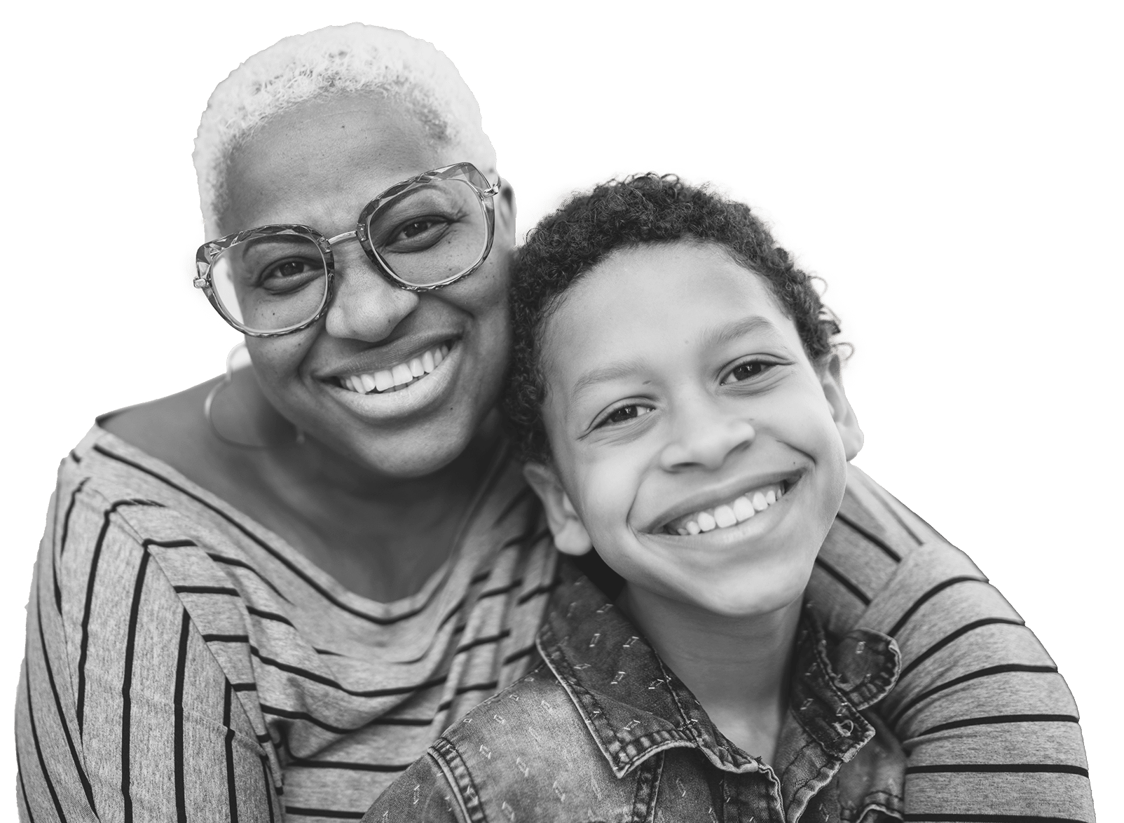 A woman with short, curly hair and glasses hugs a smiling boy. They both look at the camera, wearing striped tops, and appear happy and close, with blurred greenery in the background.