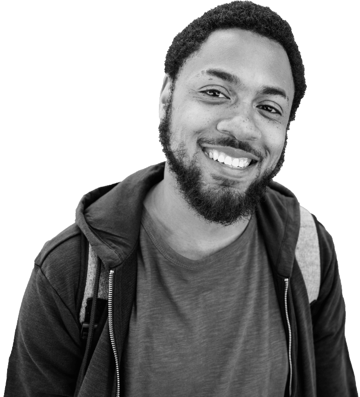 A young man with a beard and short curly hair smiles at the camera. He is wearing a t-shirt, a hoodie, and a backpack. The background is white.