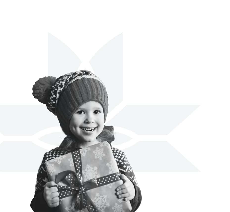 A smiling child in a winter hat and sweater holds a wrapped gift with a bow. The background is white with a subtle, light geometric snowflake pattern.