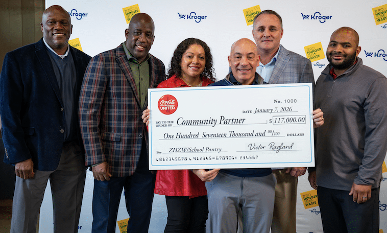 Six people stand together smiling as one holds a large ceremonial check for $117,000 made out to Community Partner from Coca-Cola United and Kroger, dated January 7, 2026, supporting food insecurity efforts through the ZHED/School Pantry.