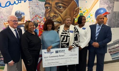 Six people stand smiling in front of a Hank Aaron mural, holding a large ceremonial check from Kroger to MUST Ministries for $278,142. They appear to be at a check presentation or charity event.